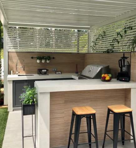 Modern outdoor kitchen with bar stools and appliances