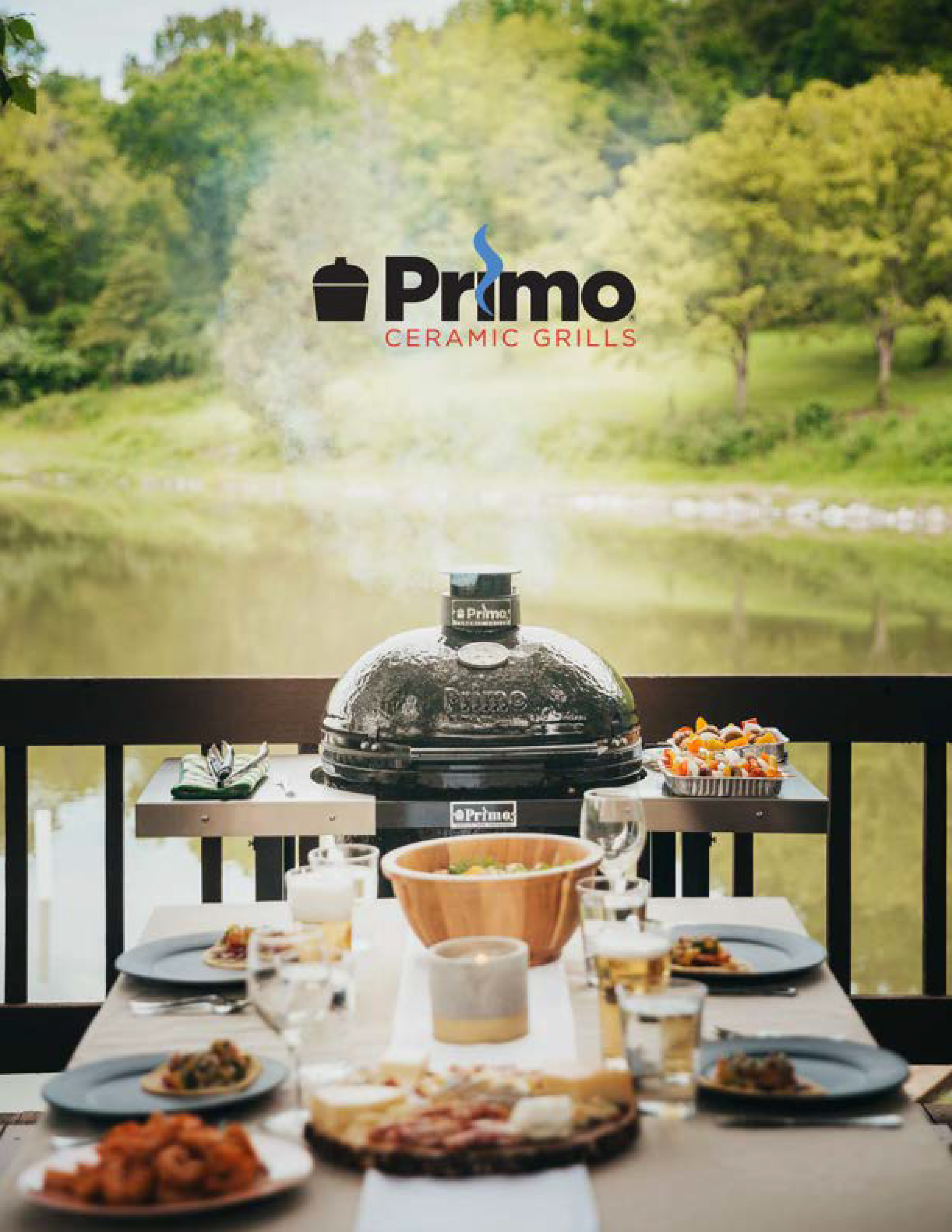 Primo ceramic grill on a table with food and drinks outdoors, featuring the Primo logo.