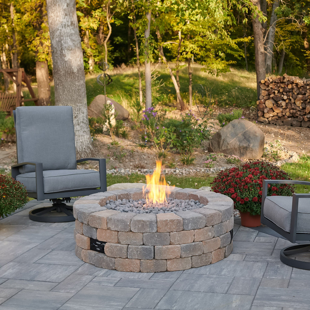 Bronson Block Round Gas Fire Pit Kit on a patio, lit