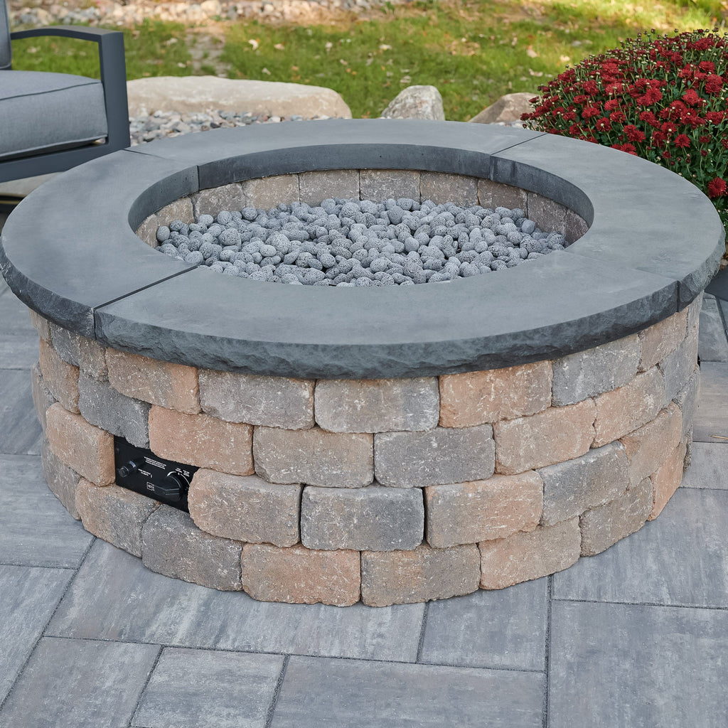 Bronson Block Round Gas Fire Pit Kit with the optional Charcoal Grey concrete top in an outdoor space