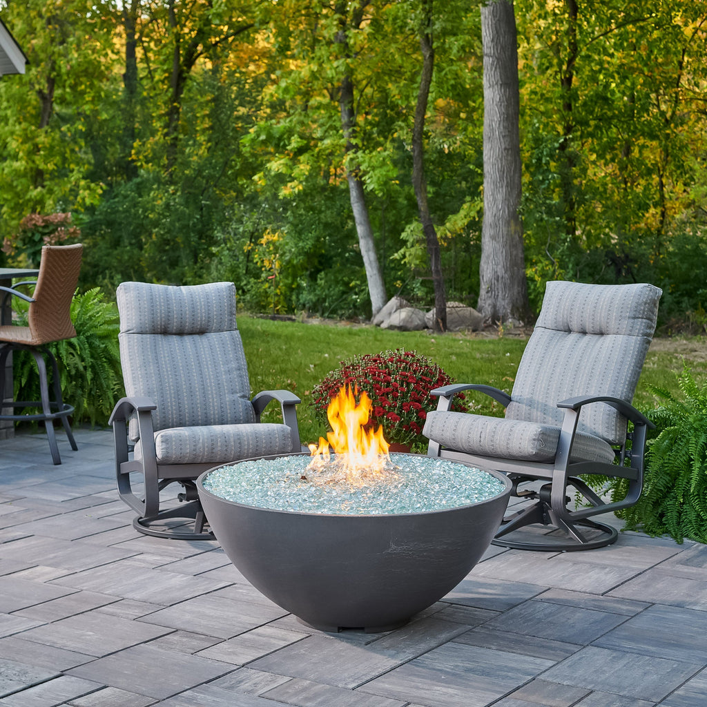 Midnight Mist Cove Concrete Edge 42-inch gas fire pit bowl with a large flame and patio furniture