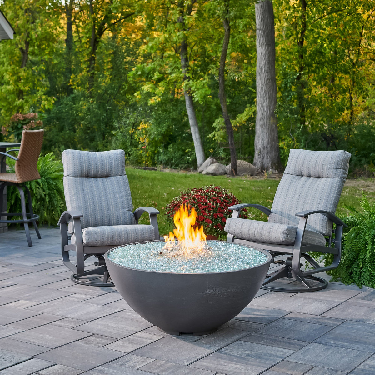 Midnight Mist Cove Concrete Edge 42-inch gas fire pit bowl with a large flame and patio furniture
