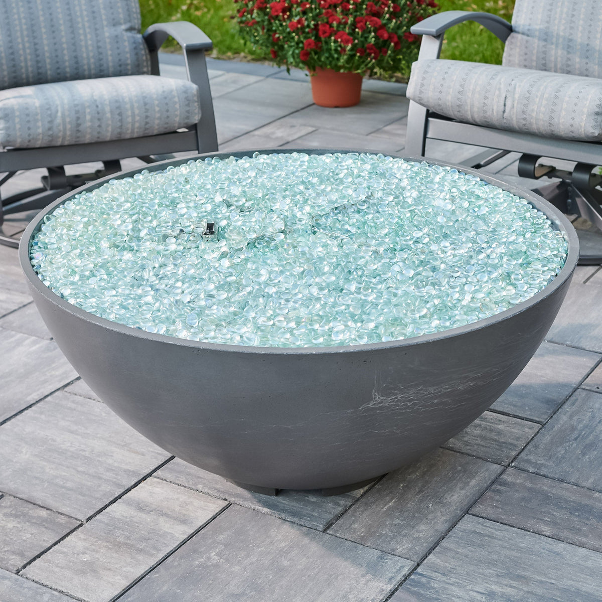 Close view of fire glass gems on the burner of a Midnight Mist Cove Concrete Edge 42-inch fire pit bowl