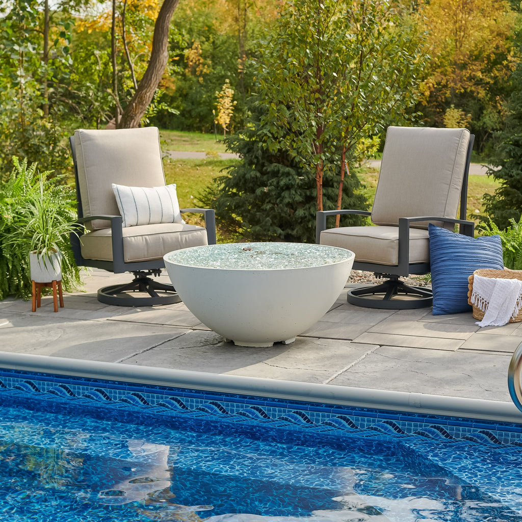 White Cove Concrete Edge 42-inch gas fire pit bowl unlit beside a pool in a backyard