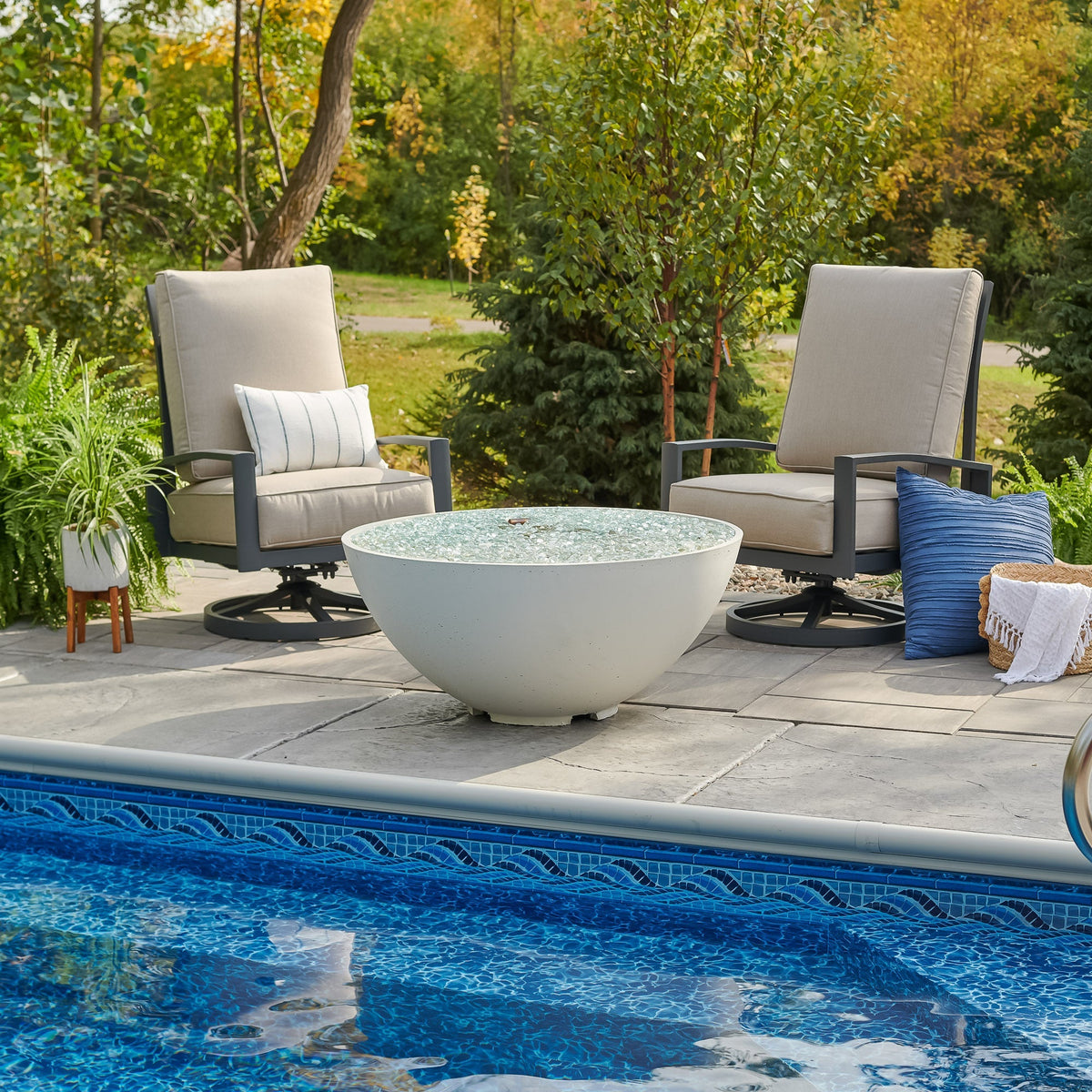 White Cove Concrete Edge 42-inch gas fire pit bowl unlit beside a pool in a backyard