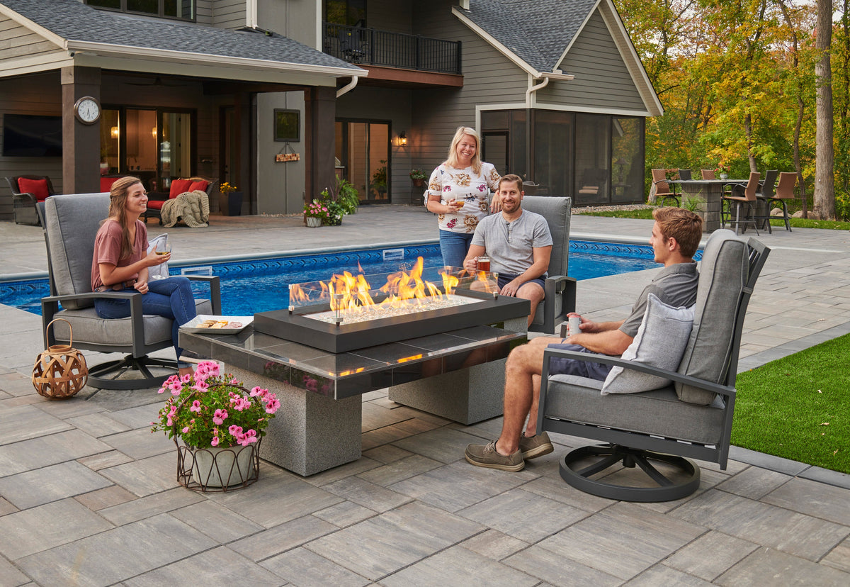 Uptown Black fire pit table lit on a patio